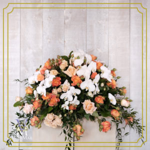 Casket Spray with hues of orange and white roses.